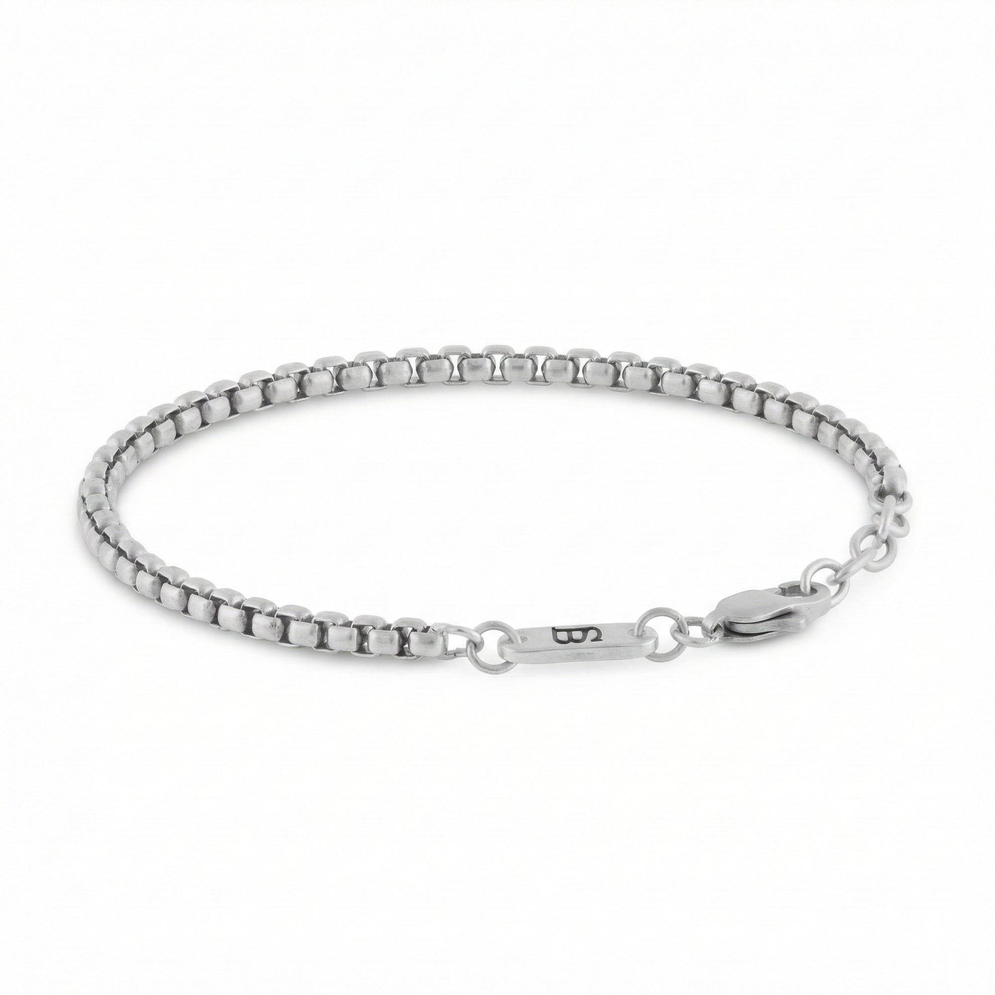 Silver stainless steel men's bracelet with box chain links and lobster clasp with small engraved tag detail on a white background
