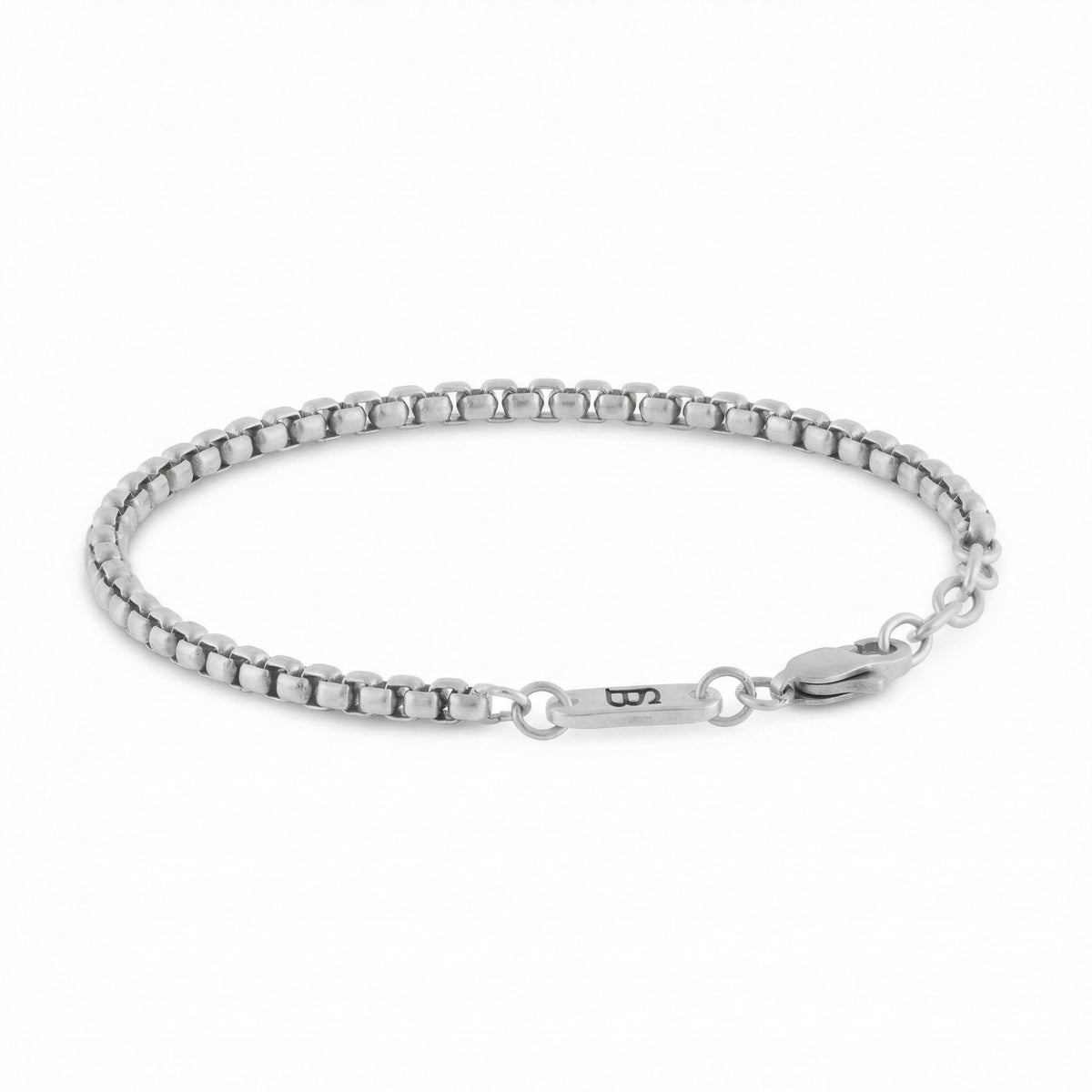 Silver stainless steel men's bracelet with box chain links and lobster clasp with small engraved tag detail on a white background