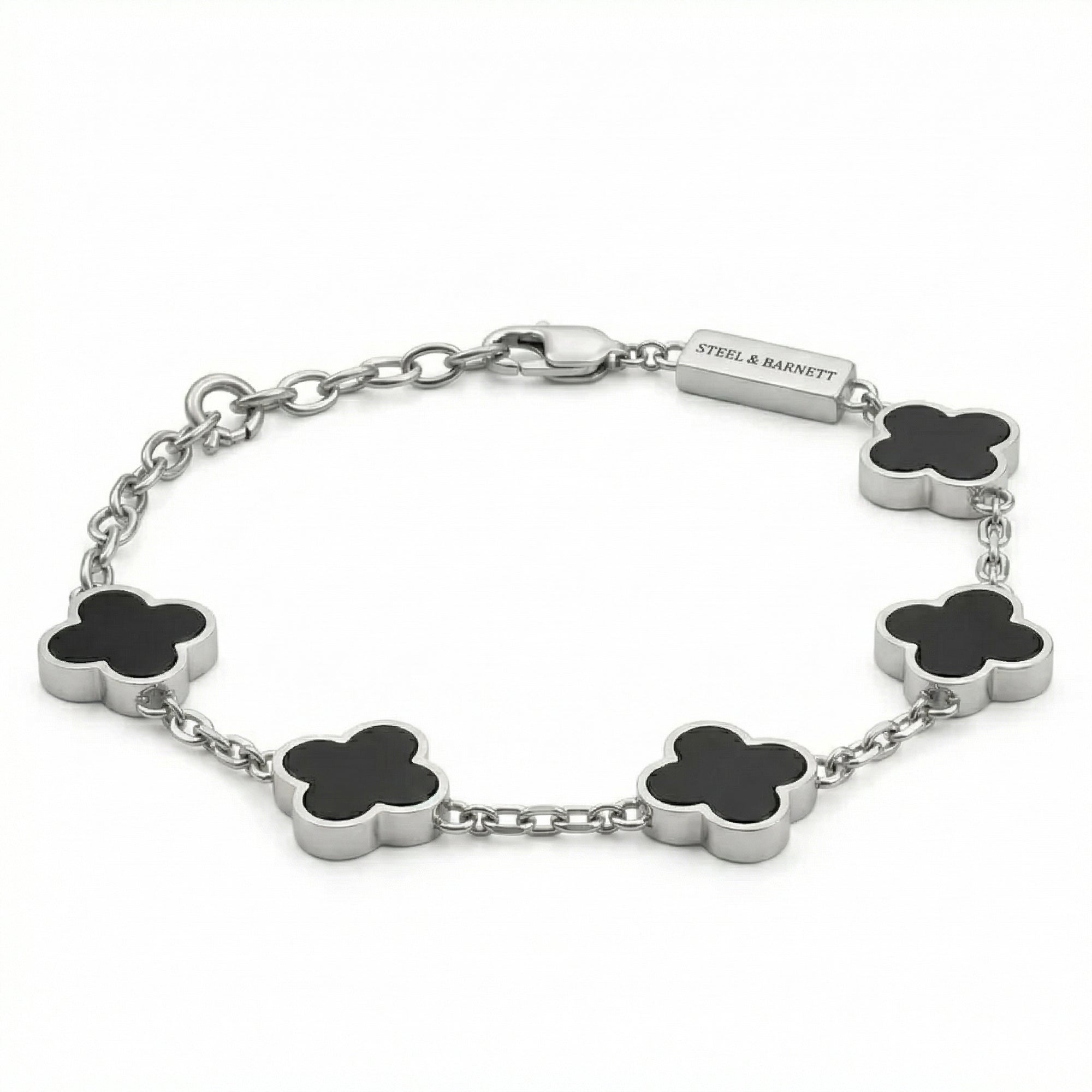 Silver toned men’s bracelet with black clover shaped inlays in stainless steel chain and lobster clasp on white background