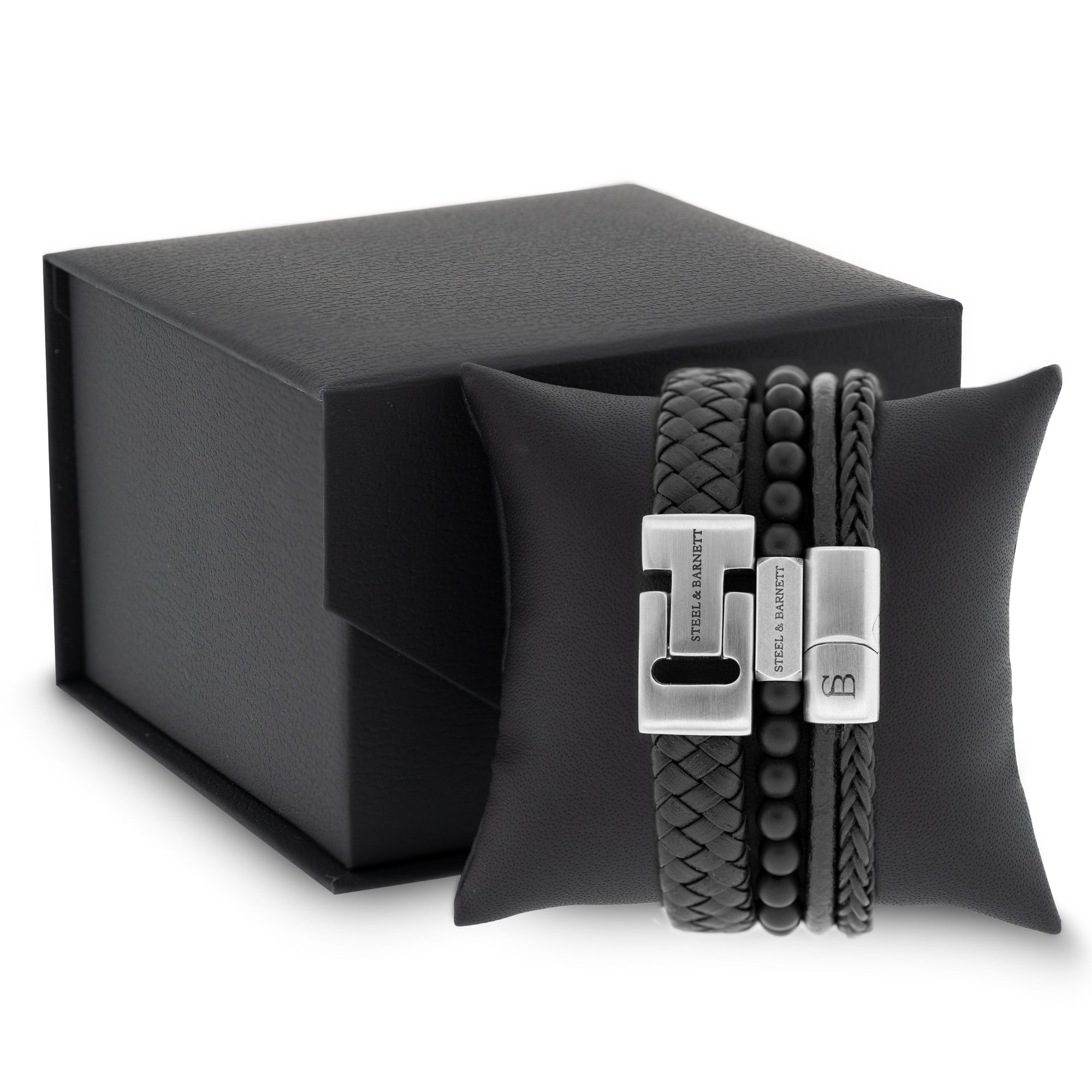 stacked men’s black leather bracelets with braided leather and matte beads displayed on a black cushion