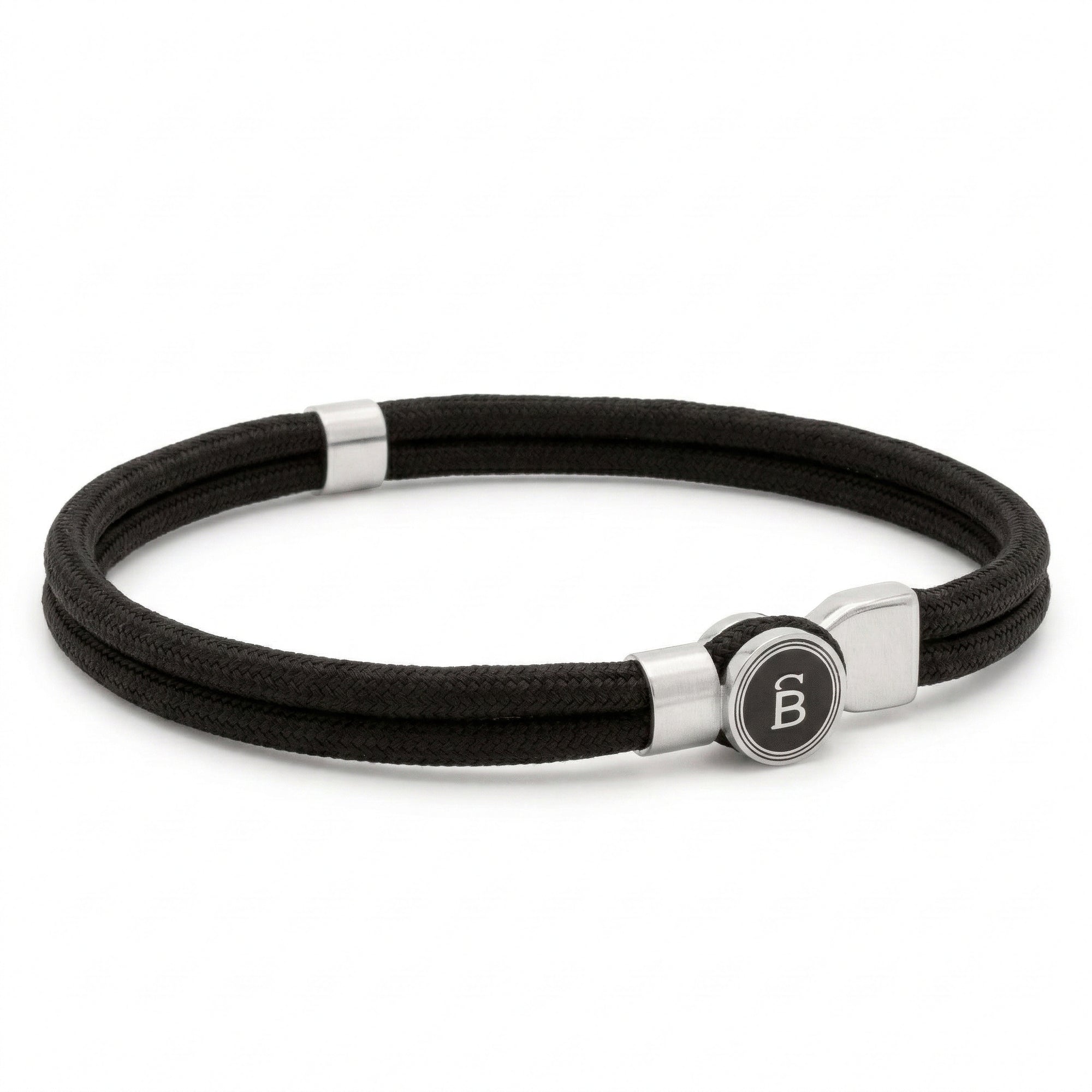 Black rope men’s bracelet with brushed stainless steel magnetic clasp and round logo detail on a white background