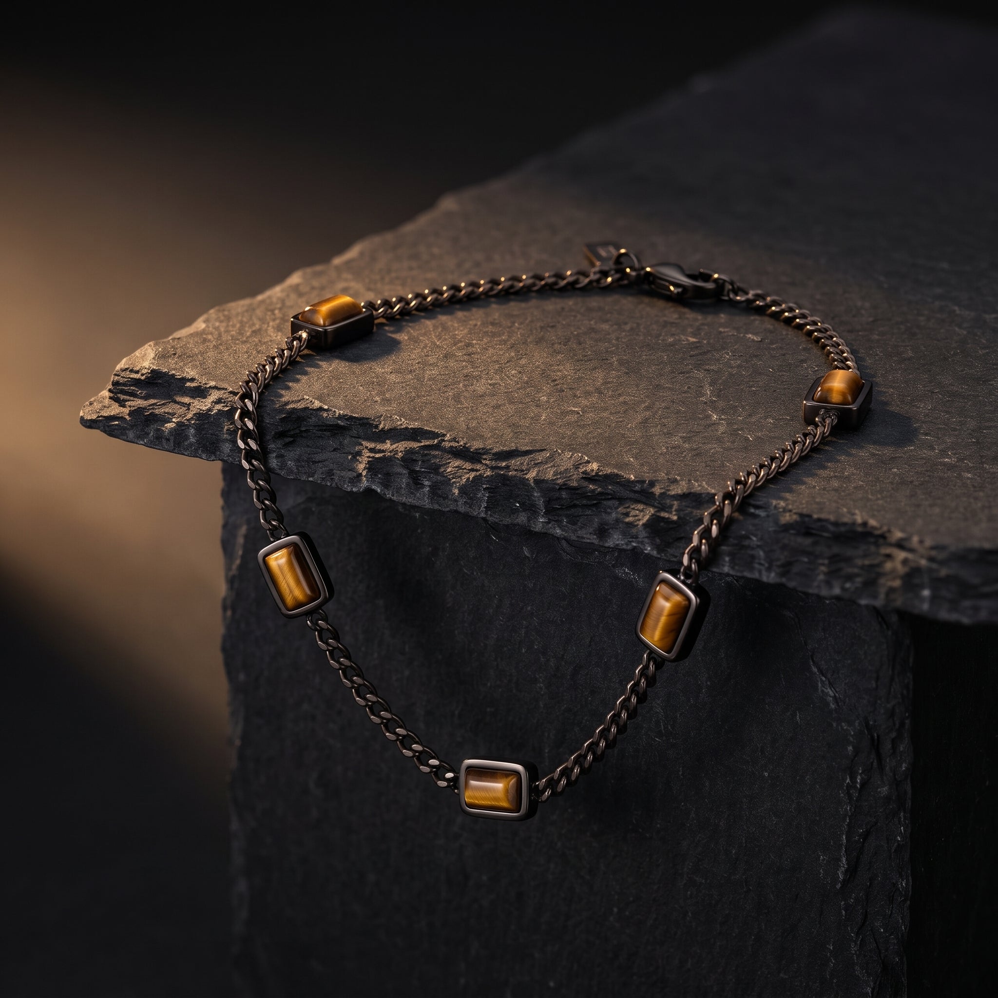Dark metal chain men's bracelet with rectangular brown stone accents worn on the wrist with a dark brown shirt