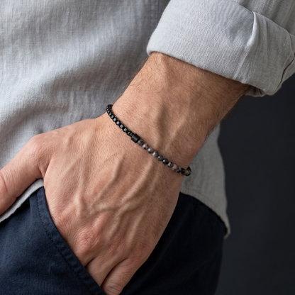 Black men's stainless steel and gemstone bracelet with minimalist chain design worn on wrist with casual styling