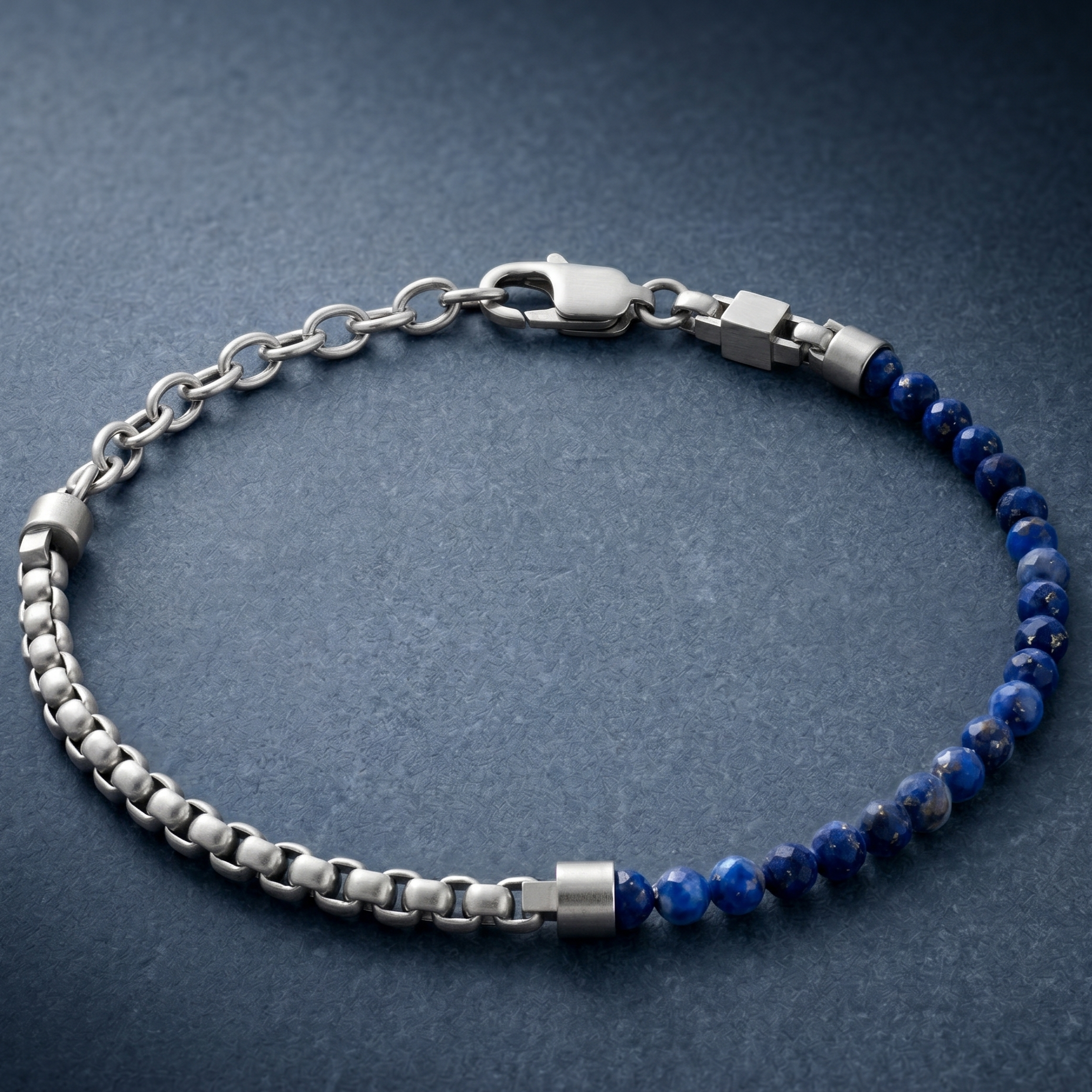 Silver men's bracelet with brushed stainless steel chain links, blue natural stone beads and lobster clasp on blue surface