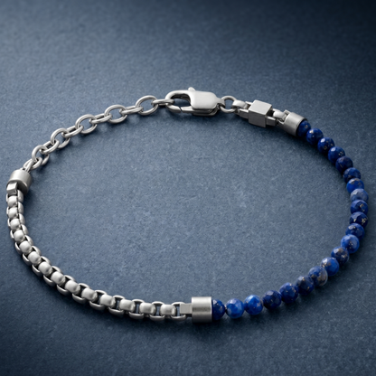 Silver men's bracelet with brushed stainless steel chain links, blue natural stone beads and lobster clasp on blue surface