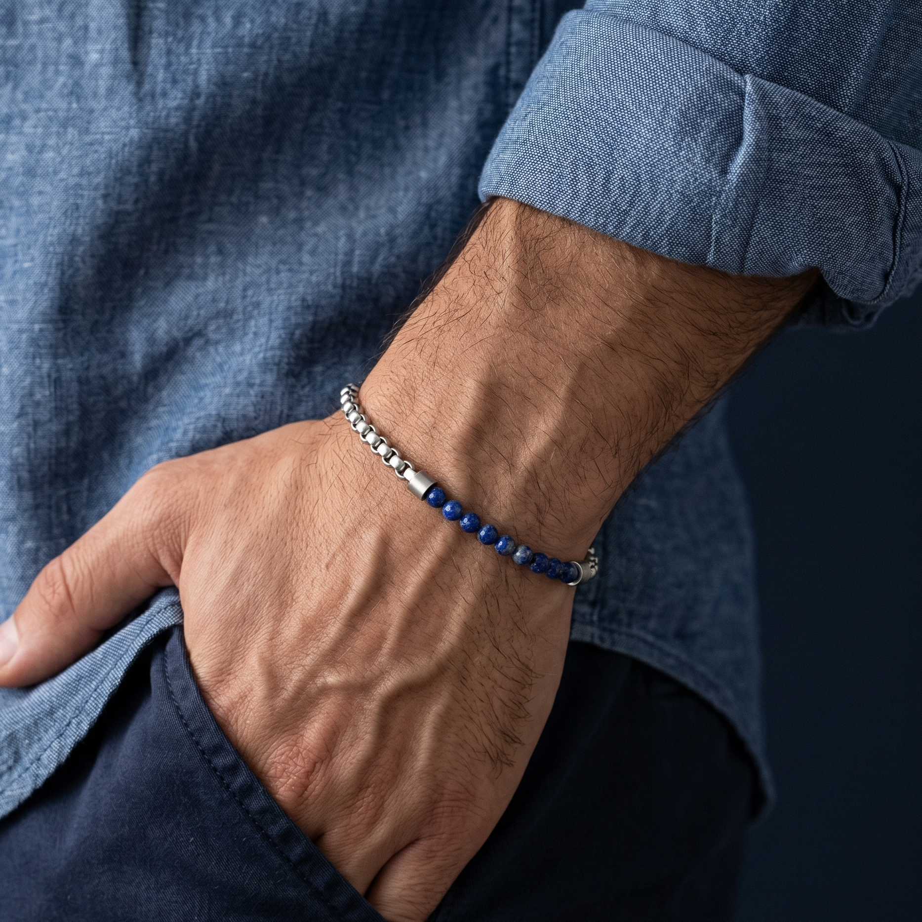 Silver men's beaded bracelet with blue gemstone beads and stainless steel chain detail shown on wrist