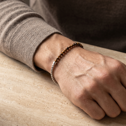 Silver men's beaded bracelet with brown tiger eye stone beads and stainless steel chain detail shown on wrist