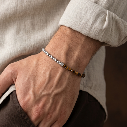 Silver men's stainless steel bracelet with brown tiger eye beads and minimalist chain detail worn on wrist