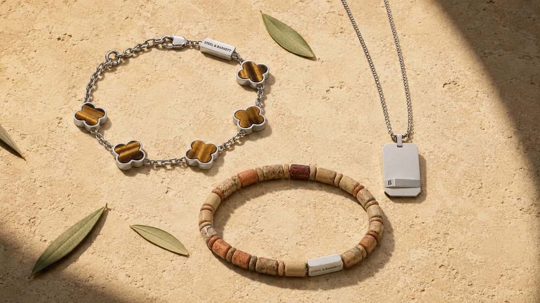 Jewelry including a bracelet, necklace, and pendant on a sandy surface with leaves.