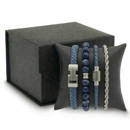 Blue leather and beaded men's bracelet set with stainless steel clasps and silver chain shown stacked on a black cushion with gift box