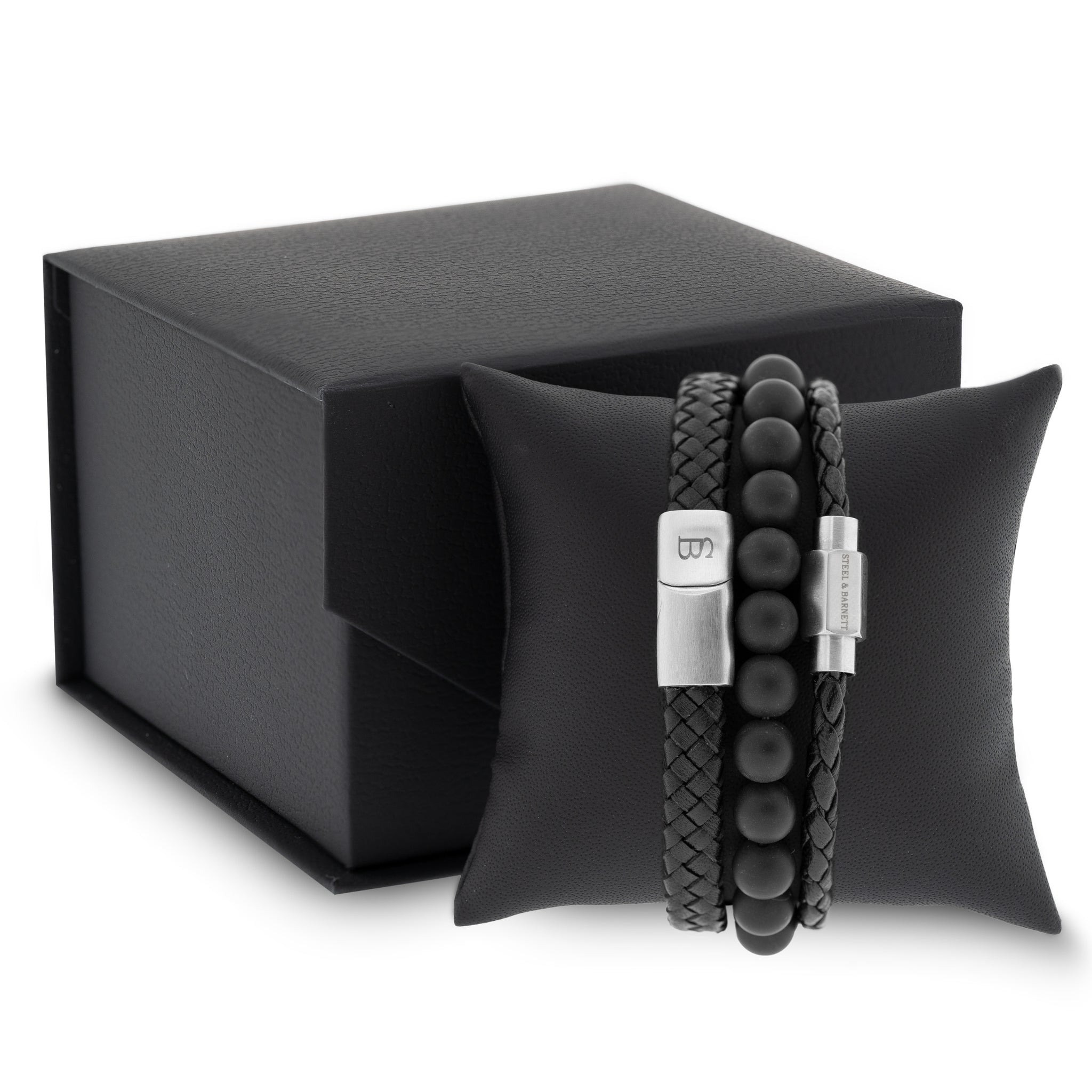 Black leather men’s bracelet set with braided and smooth bands and matte black beads displayed on a black cushion with gift box