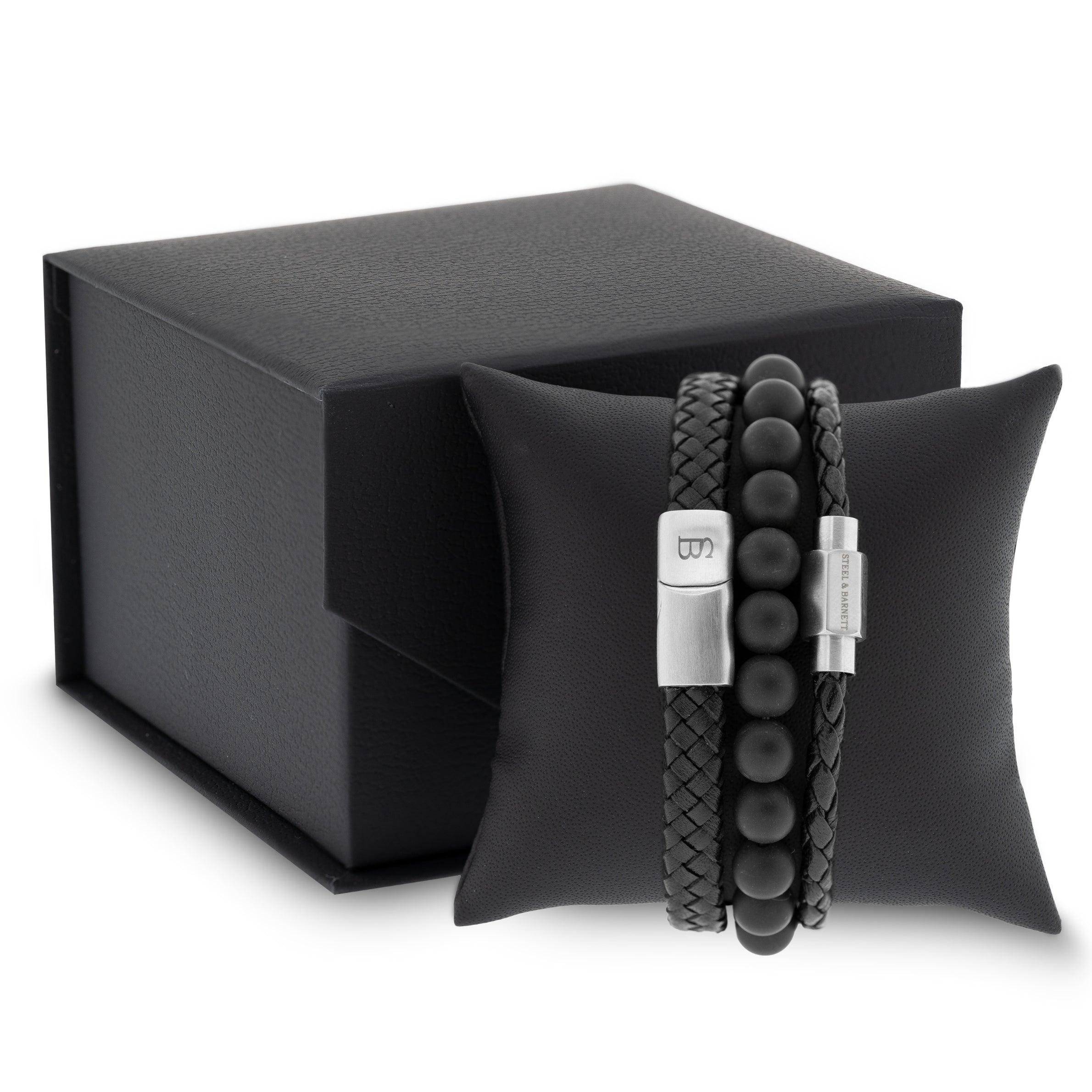 Black leather men’s bracelet set with braided and smooth bands and matte black beads displayed on a black cushion with gift box