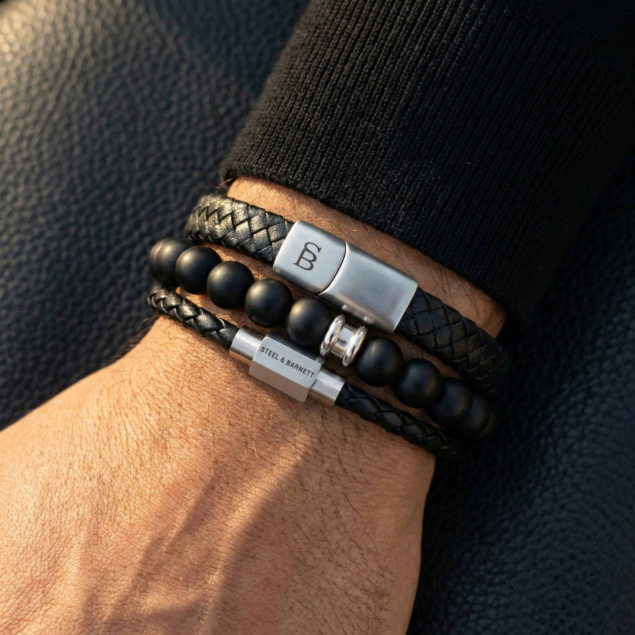 Black braided leather men’s bracelet stack with matte black bead bracelet and brushed stainless steel magnetic clasps worn on wrist