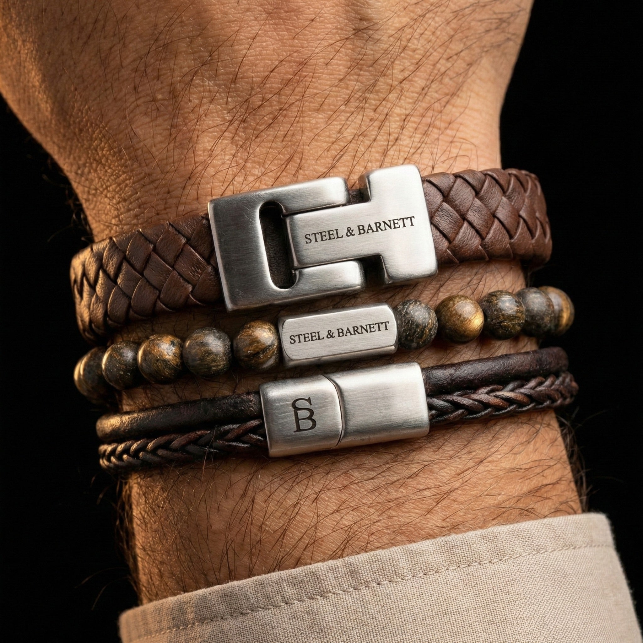 stacked men’s brown leather bracelets with braided leather and natural stone beads featuring brushed stainless steel clasps shown on wrist