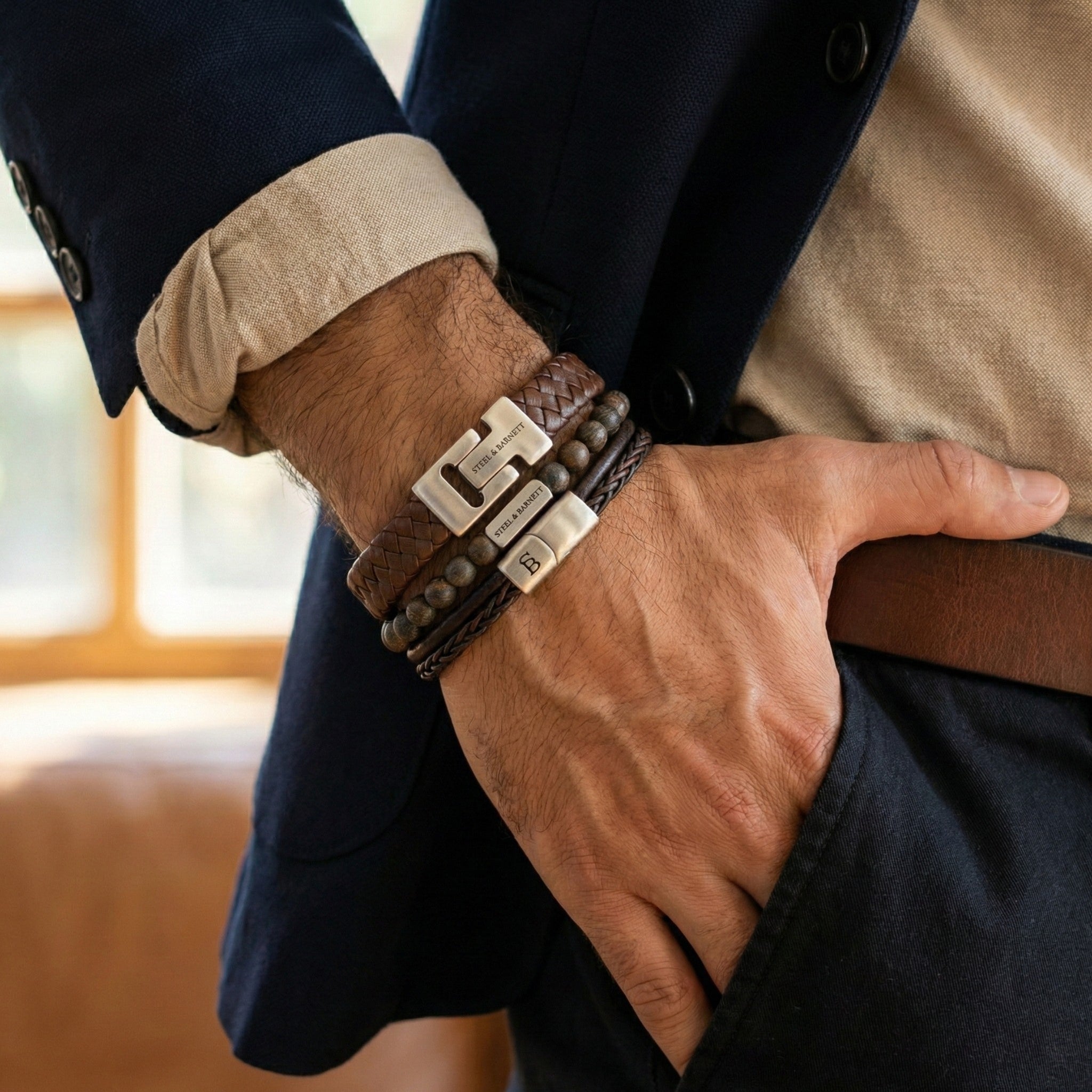 stacked men’s brown leather bracelets with braided leather and natural stone bead design featuring brushed stainless steel clasps worn on wrist