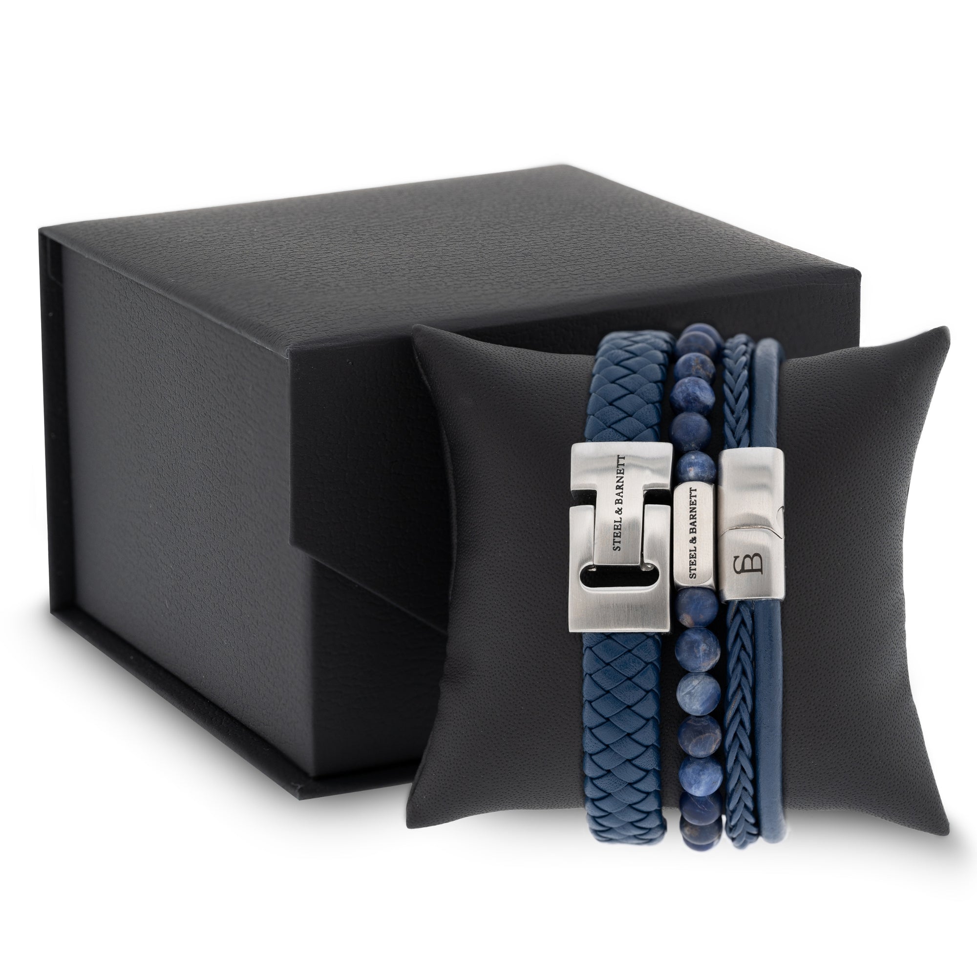Blue leather men’s bracelet set with braided and smooth bands, natural stone beads and brushed stainless steel clasps displayed on a black cushion