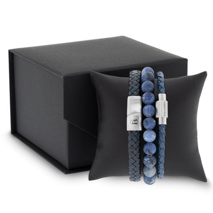 Blue leather men’s bracelet set with braided and smooth bands and natural stone beads displayed on a black cushion with gift box