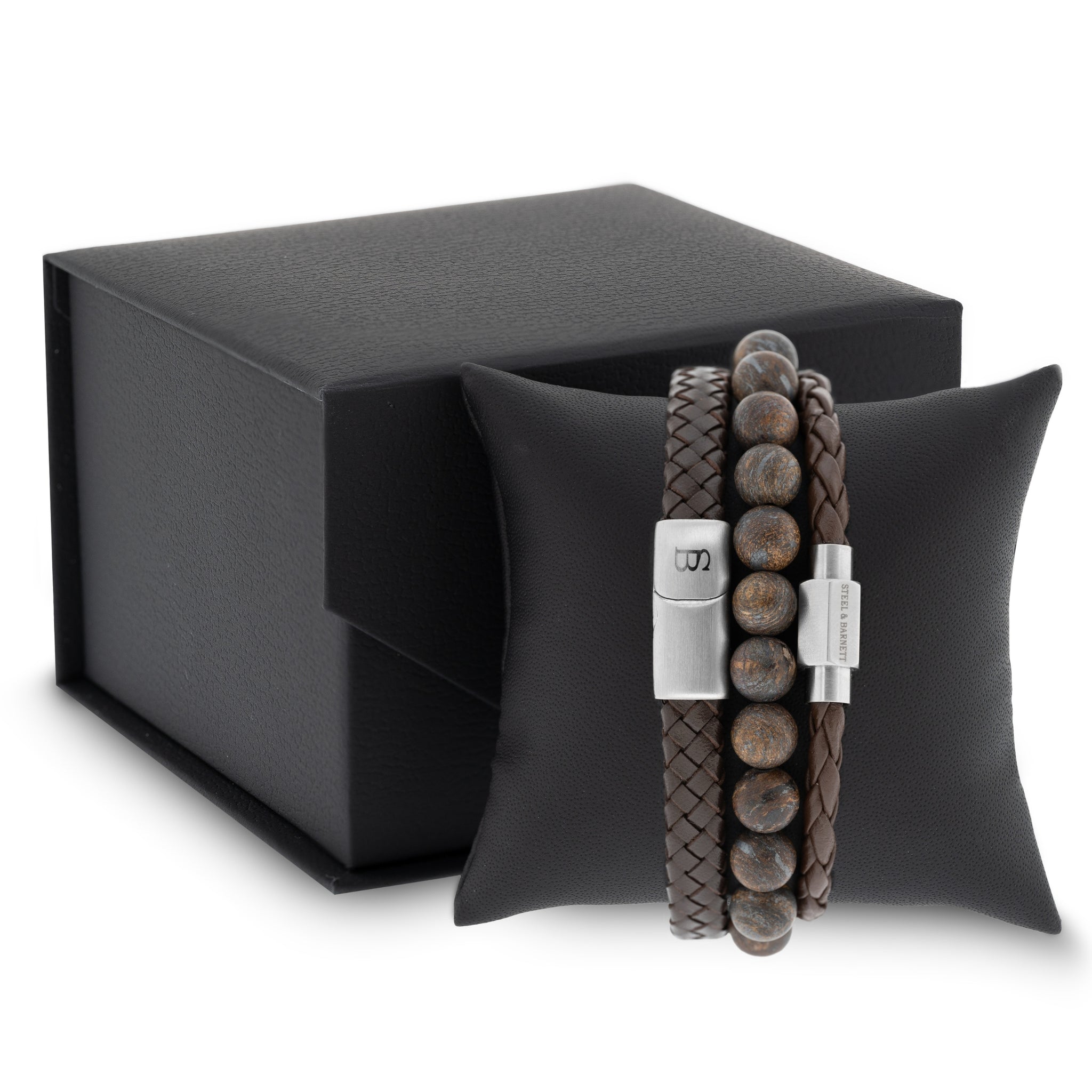 Brown leather men’s bracelet set with braided and smooth bands and natural stone beads displayed on a black cushion with gift box