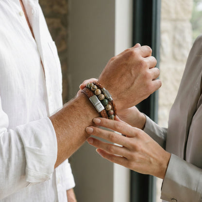 Layered cognac leather men’s bracelet set with multicolor natural stone bead bracelet and brushed stainless steel clasps worn on wrist indoors
