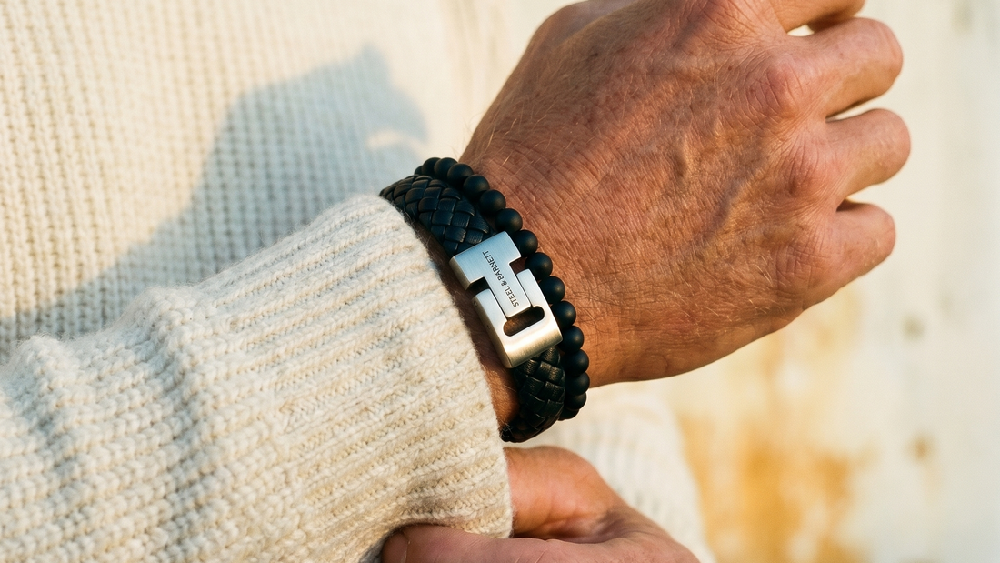 Black braided leather men's bracelet with stainless steel magnetic clasp stacked with matte black beaded bracelet worn on wrist