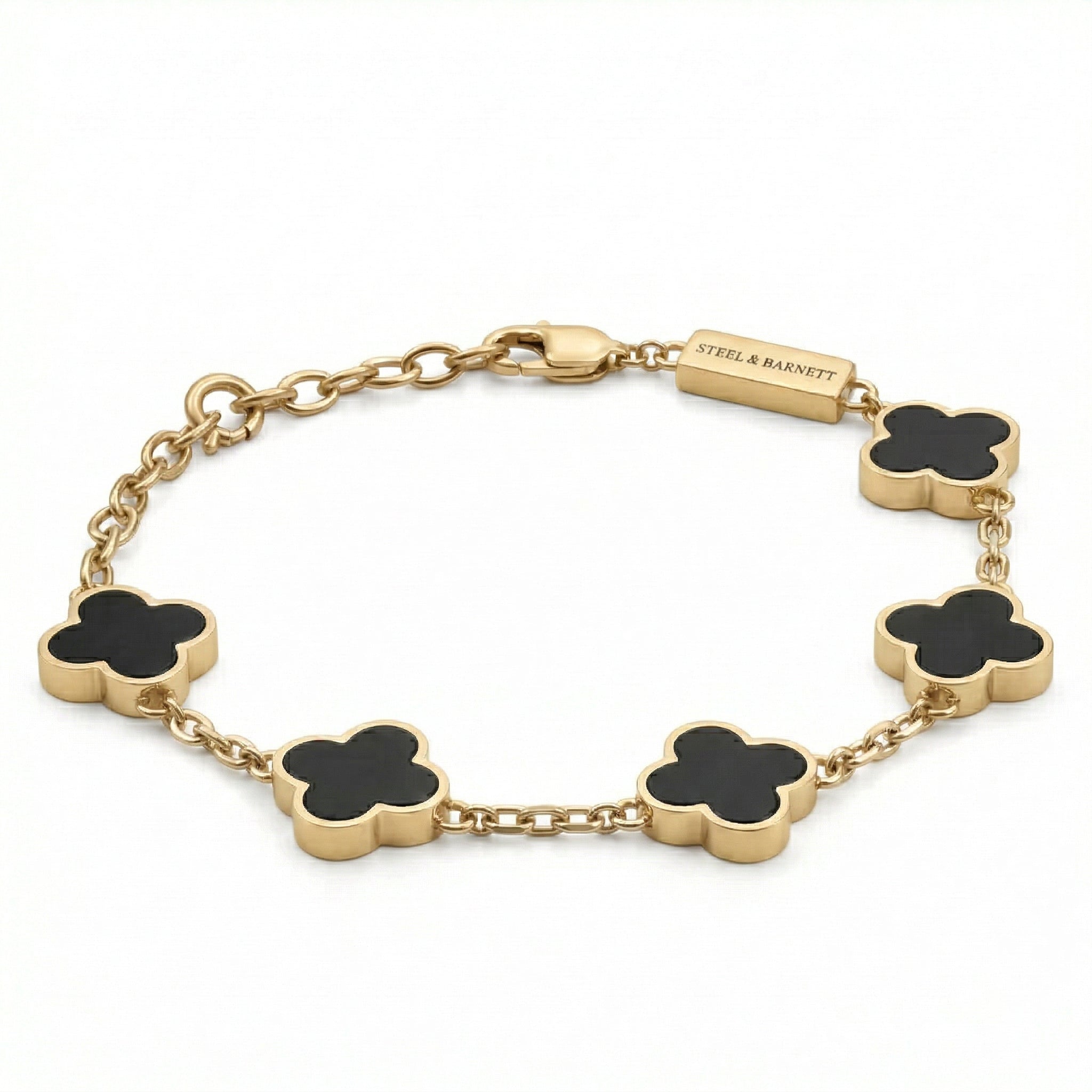Gold toned men’s bracelet with black clover shaped inlays linked by a chain and lobster clasp on a white background