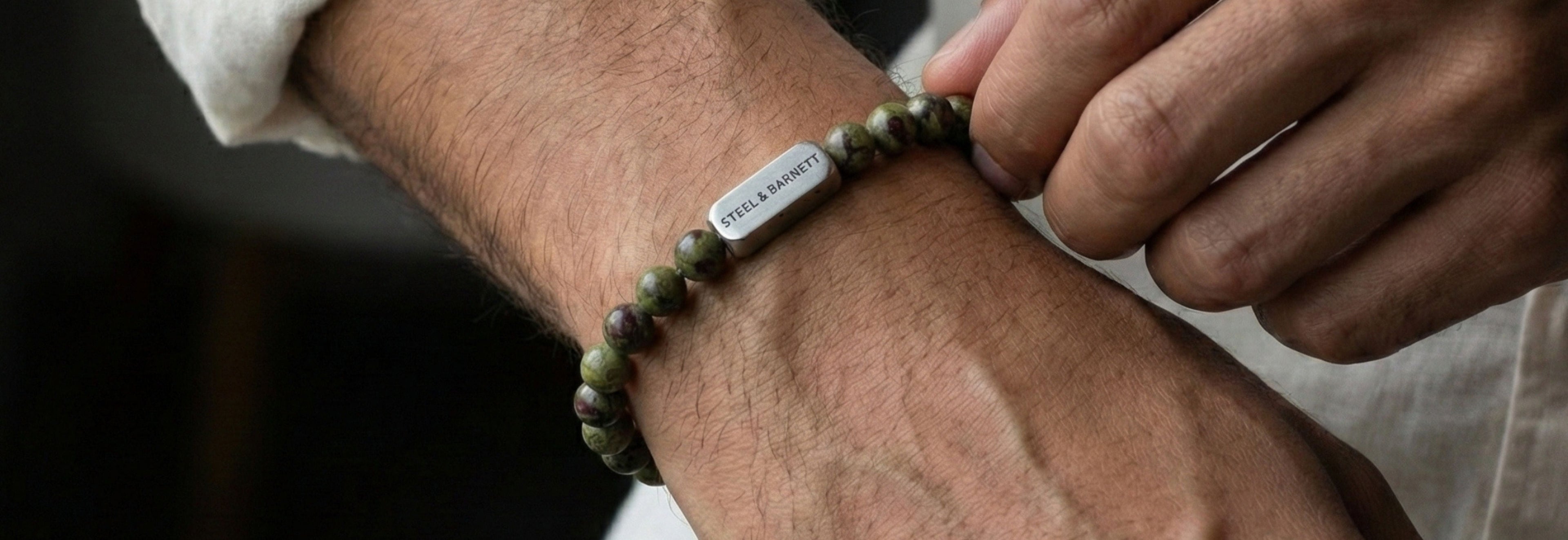Green natural stone men’s bracelet with round beads and a silver tone metal accent, shown worn on the wrist