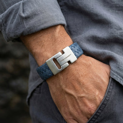 Blue braided leather men’s bracelet with brushed stainless steel clasp shown on wrist in a casual setting