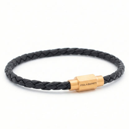 Black braided leather men’s bracelet with plated 18K gold clasp on a white background