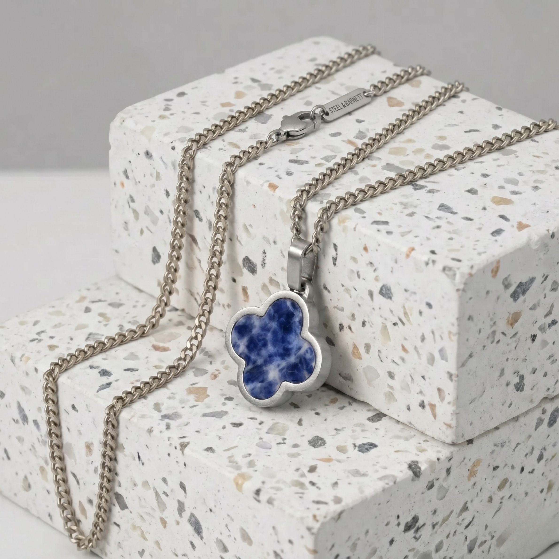 Necklace with a blue sodalite pendant on a textured surface