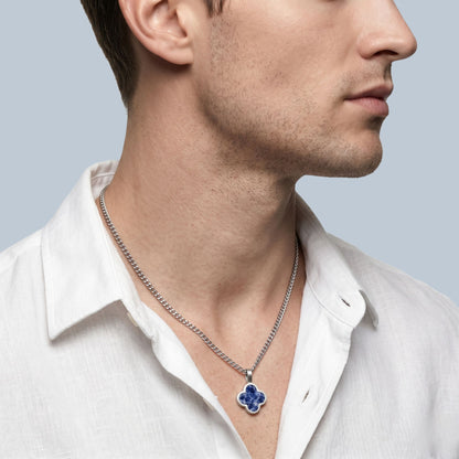 Man wearing a silver necklace with a sodalite blue pendant on a light gray background