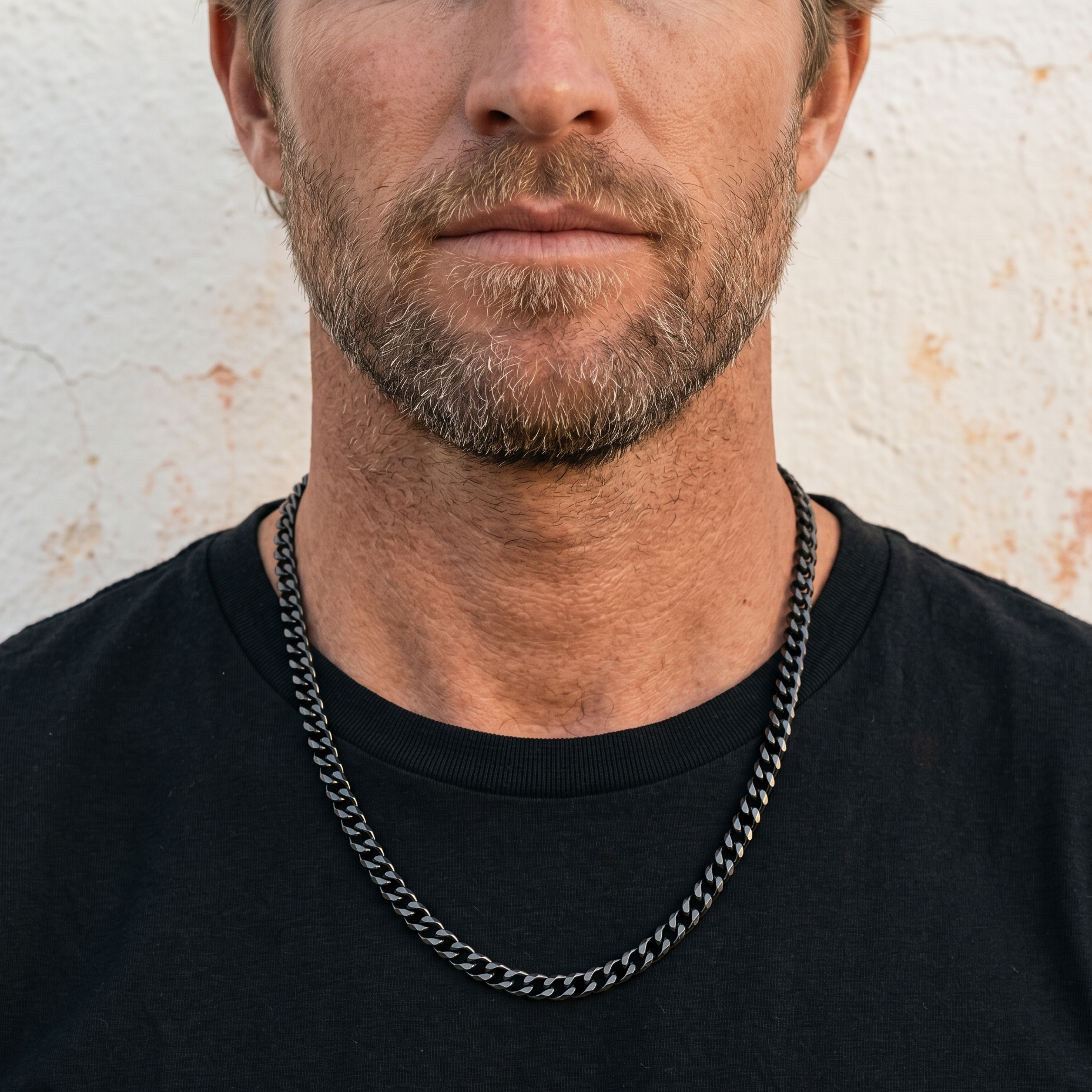 Black stainless steel men's necklace with polished curb chain design worn close up on model with black shirt