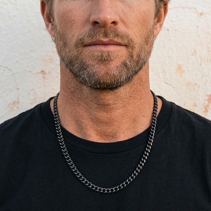 Black stainless steel men's necklace with polished curb chain design worn close up on model with black shirt