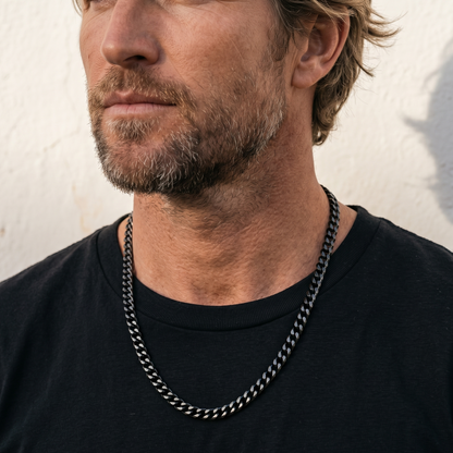 Black stainless steel men's necklace with polished curb chain design worn close up on model with black shirt