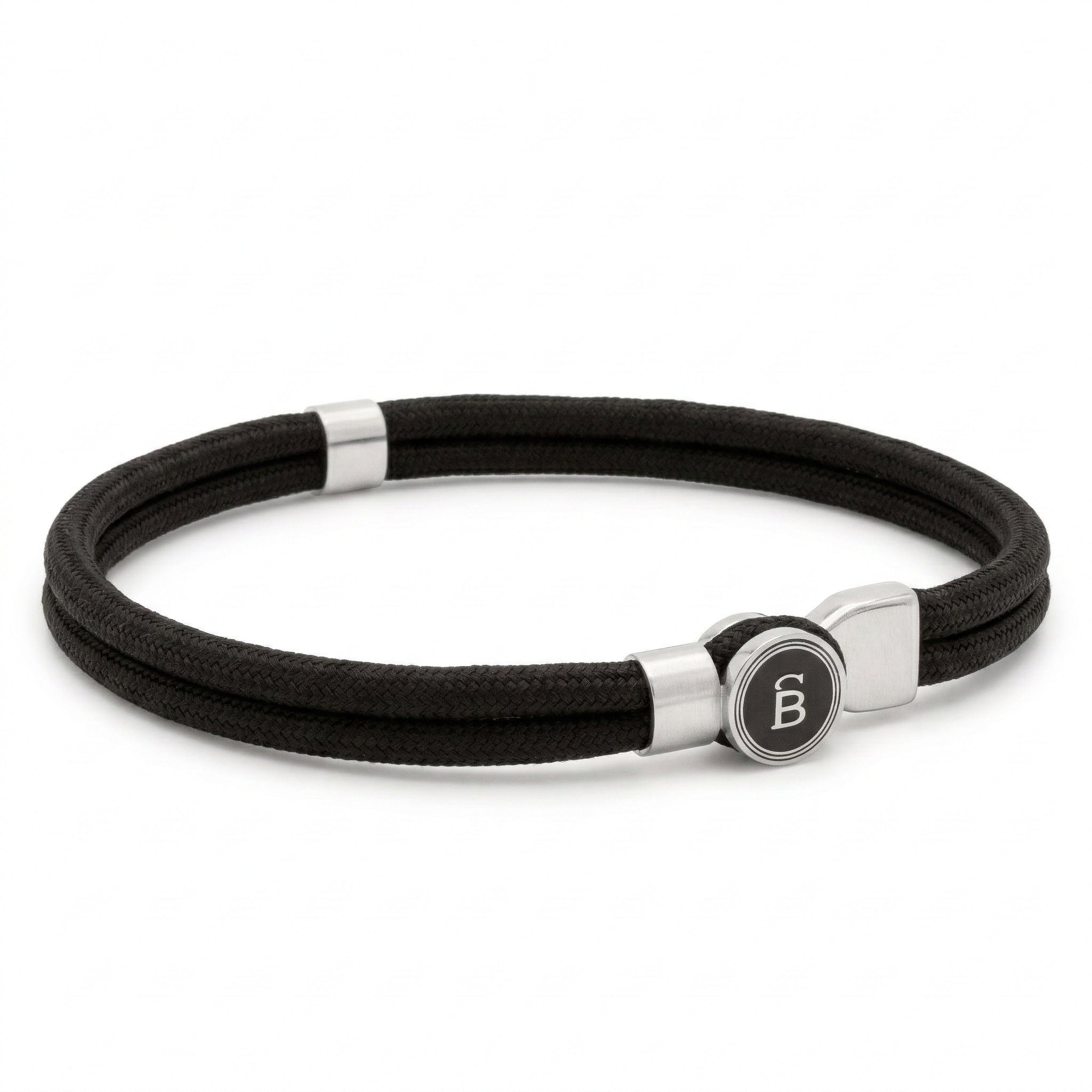 Black rope men’s bracelet with brushed stainless steel magnetic clasp and round logo detail on a white background