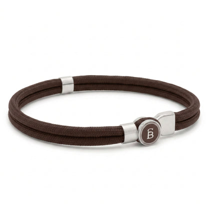 Brown rope men’s bracelet with brushed stainless steel magnetic clasp and round logo detail on a white background