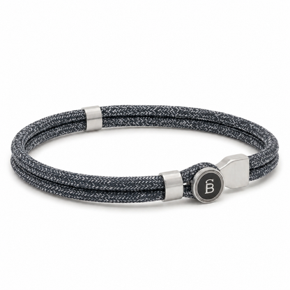 Grey braided rope men’s bracelet with brushed stainless steel magnetic clasp and round logo detail on a white background