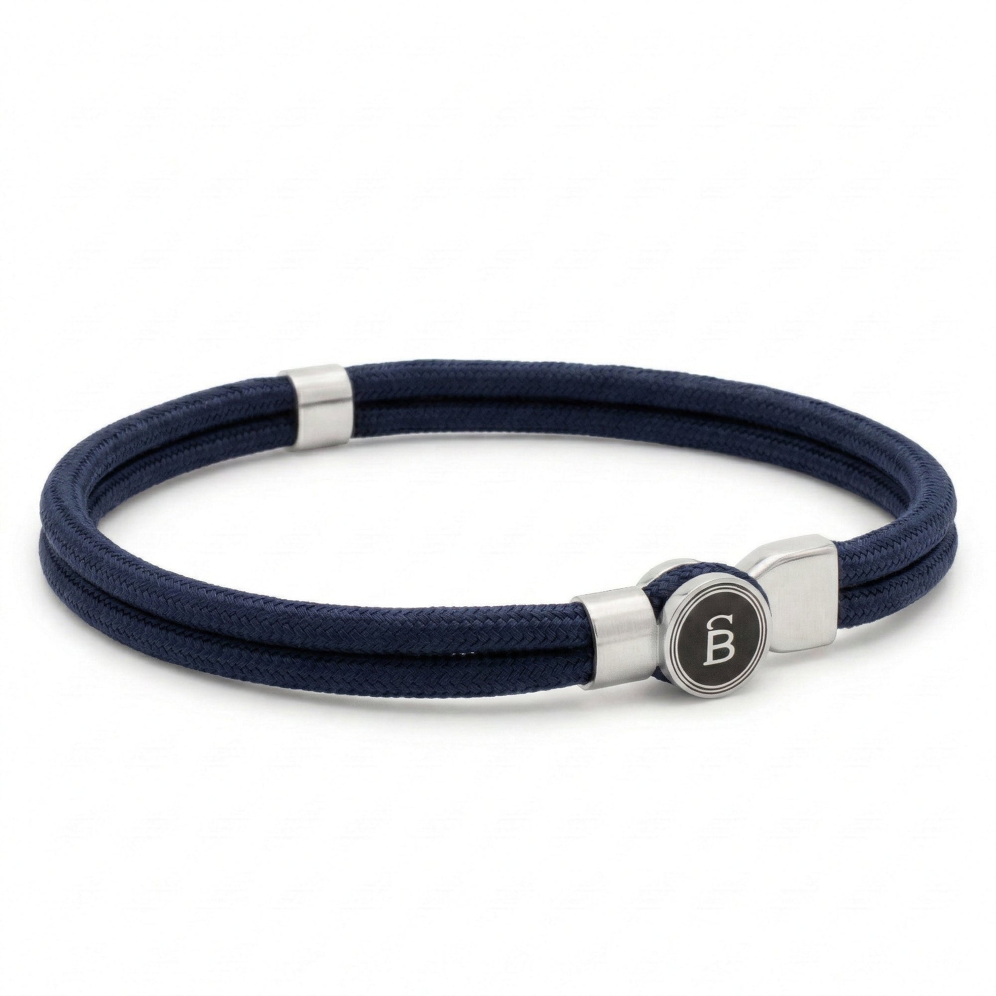 Navy blue rope men’s bracelet with brushed stainless steel magnetic clasp and round logo detail on a white background