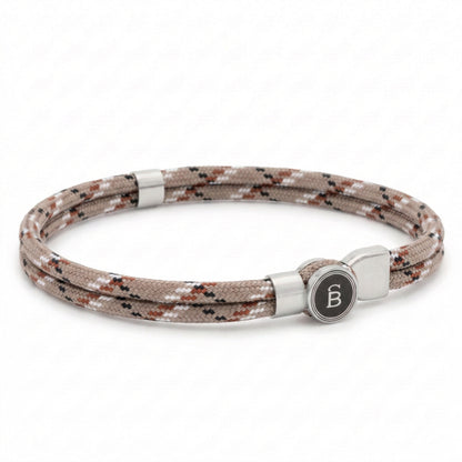 Beige patterned rope men’s bracelet with brushed stainless steel magnetic clasp and round logo detail on a white background
