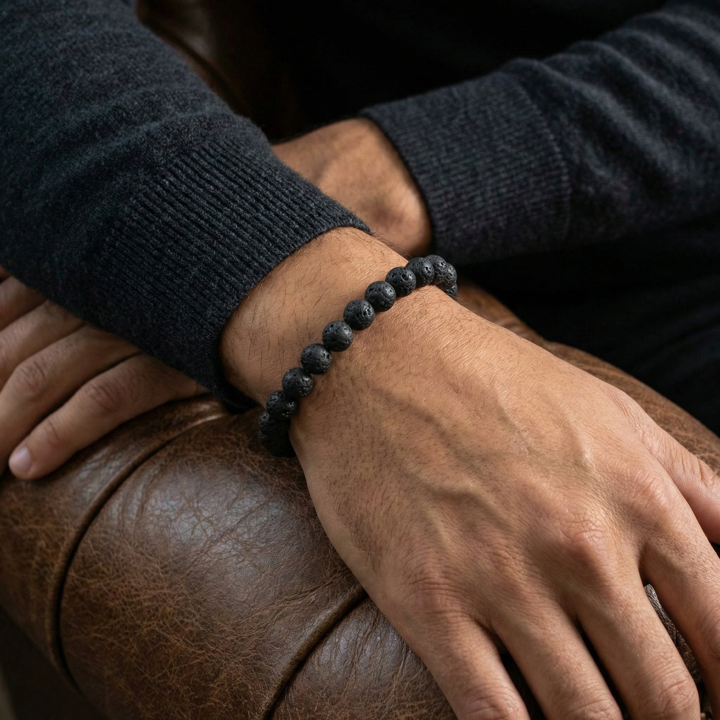 Black lava stone men’s bracelet with matte natural stone beads worn on wrist in a lifestyle setting