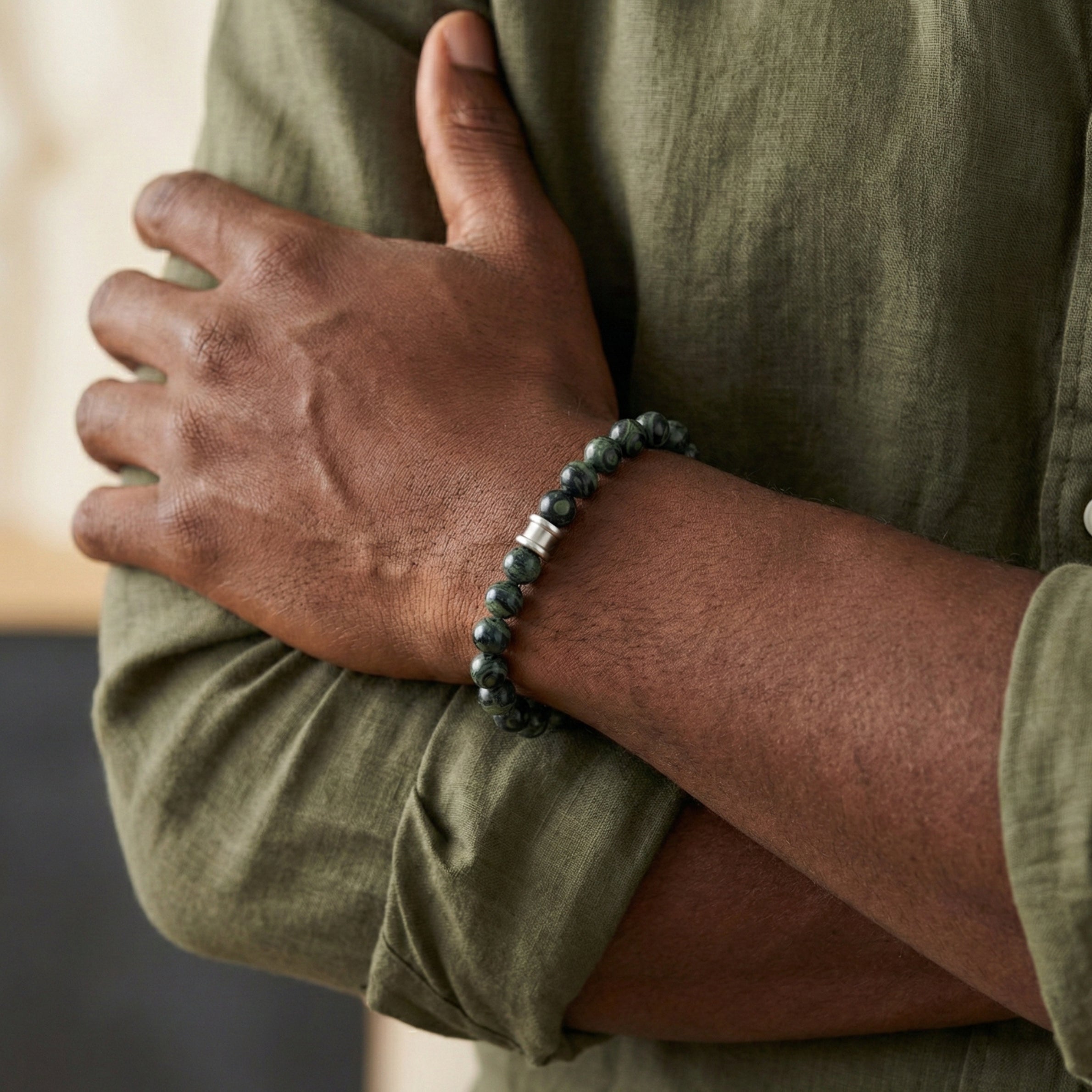 Green kambaba gemstone men’s bracelet with polished natural stone beads and stainless steel detail worn on wrist