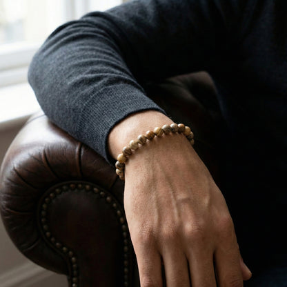 Beige and brown beaded men’s bracelet with matte natural stone beads and stainless steel detail worn on wrist