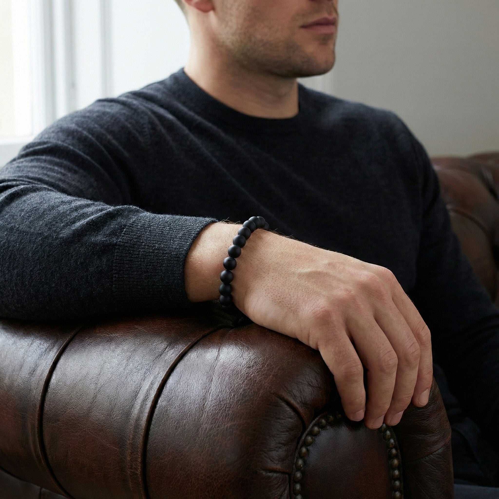 Black onyx men’s bracelet with matte natural stone beads worn on wrist in a lifestyle setting