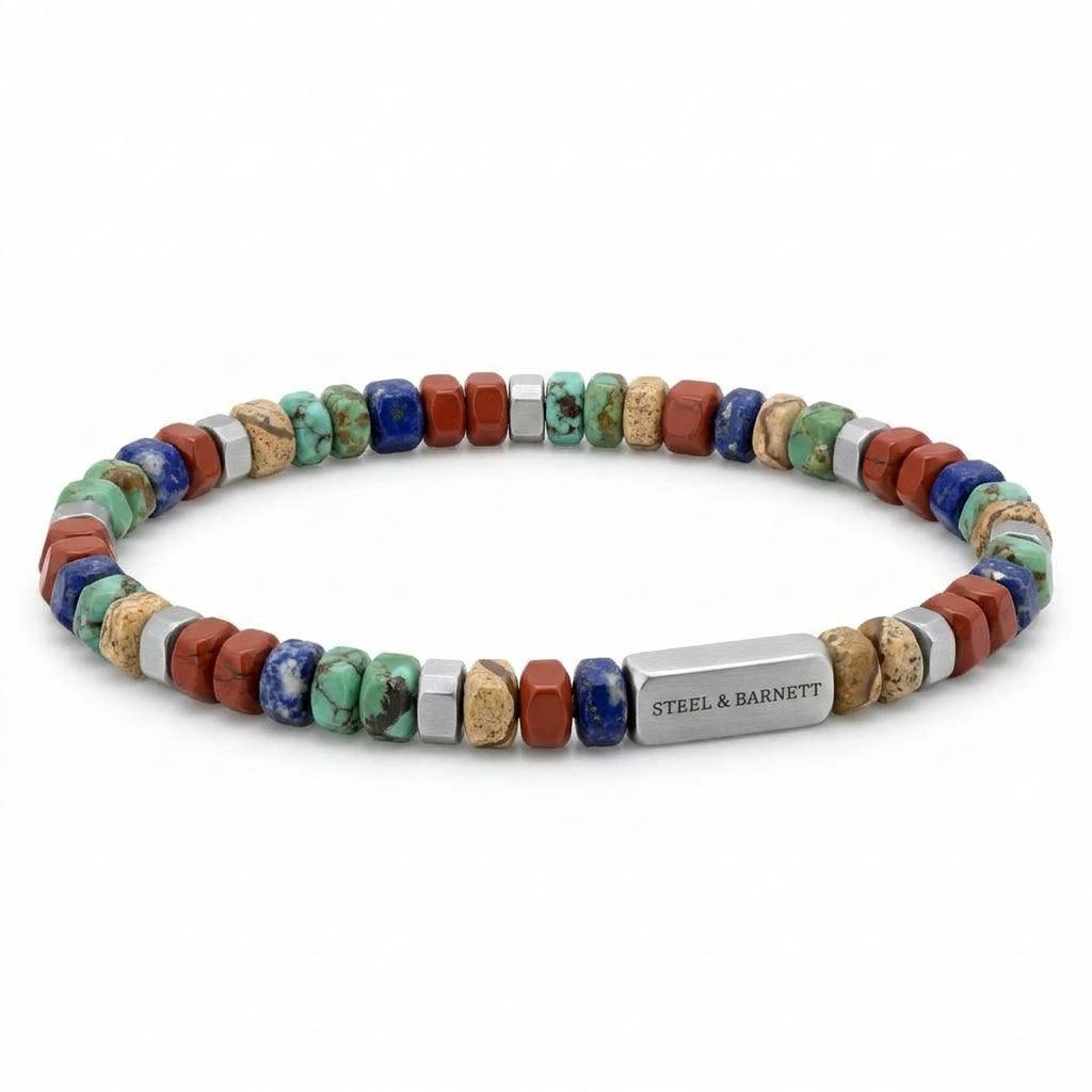 A beaded stretch bracelet by Steel & Barnett, featuring a mix of colorful natural stones in blue, green, red, and tan, accented by silver-toned metal beads and a central rectangular silver clasp engraved with the brand name.