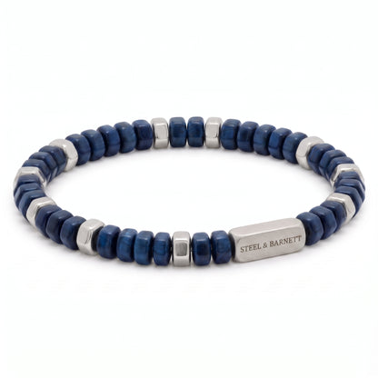 A beaded stretch bracelet featuring dark blue faceted beads and polished silver-tone metal spacer beads, with a rectangular silver clasp engraved with the brand name 'STEEL & BARNETT'.