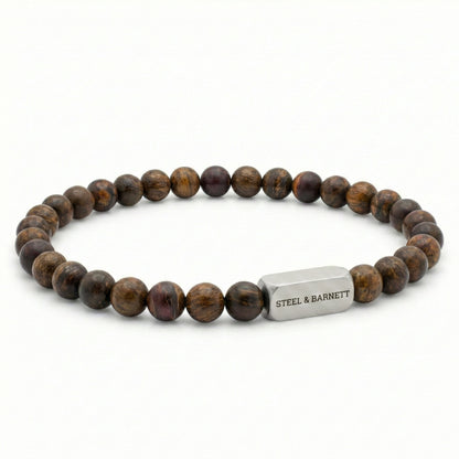 Bronzite beaded men’s bracelet with round brown natural stone beads and brushed stainless steel bar on white background