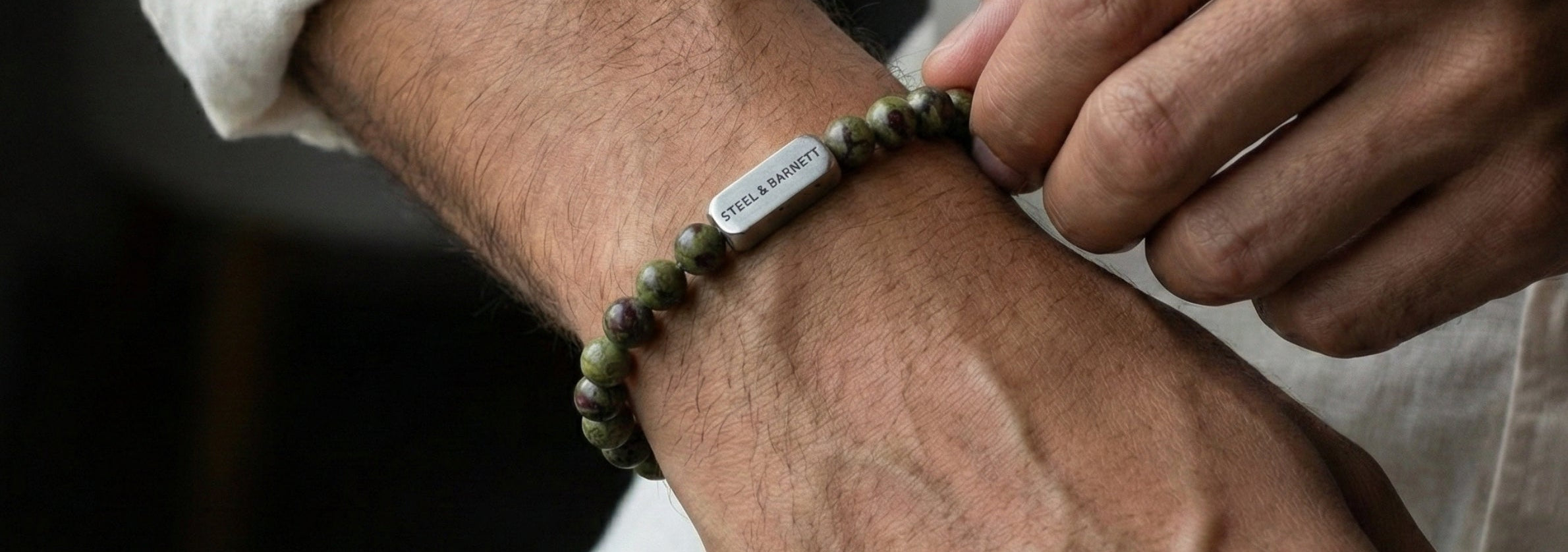 Person wearing a bracelet on a dark background