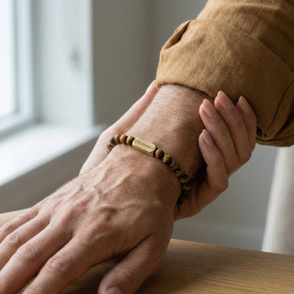 Tiger eye men’s bracelet with brown and gold stone beads and plated 18K gold clasp worn on wrist