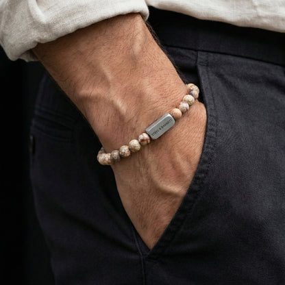 Maifanite men’s bracelet with natural stone beads and brushed stainless steel bar worn on wrist with hand in pocket