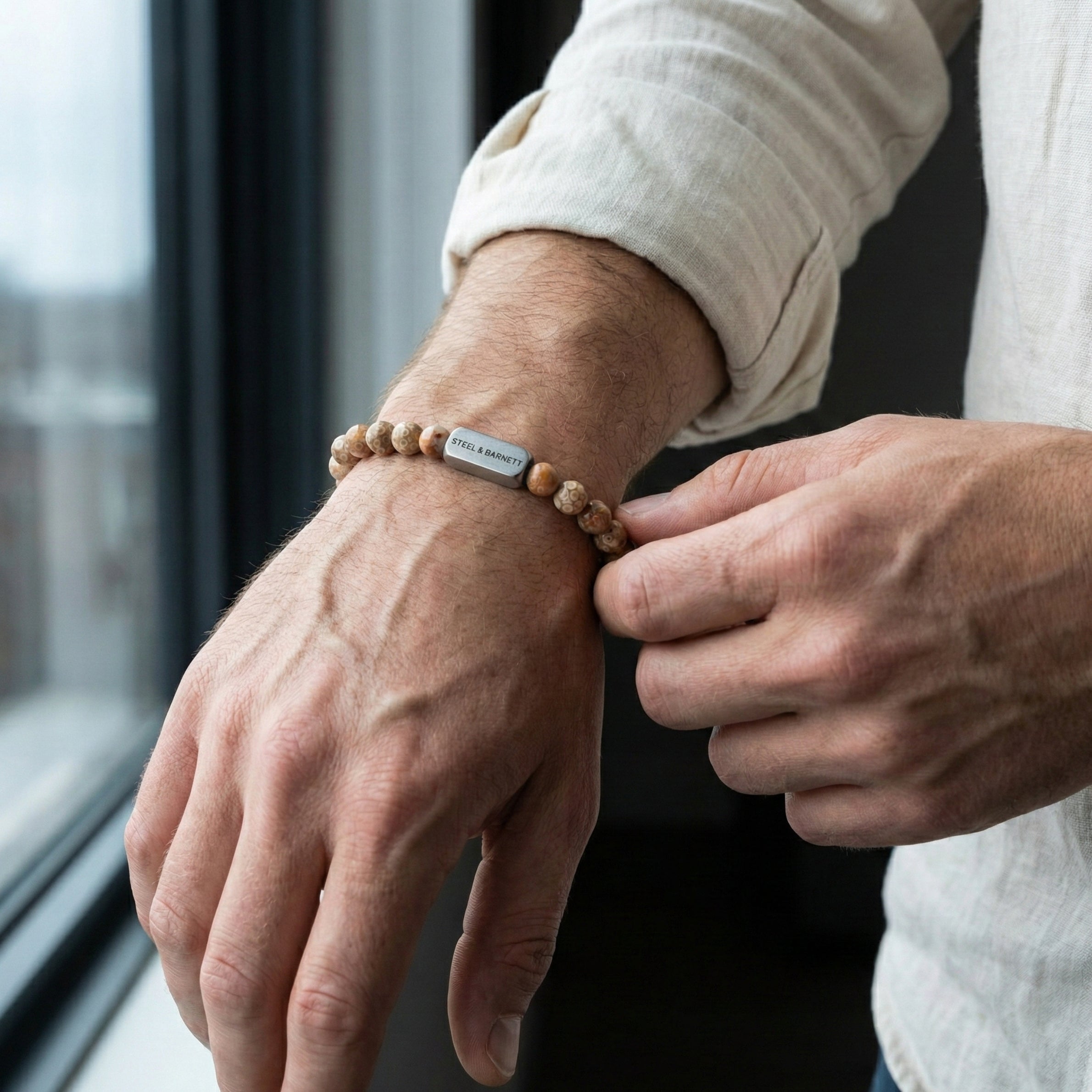 Maifanite men’s bracelet with round stone beads and brushed stainless steel bar worn on wrist