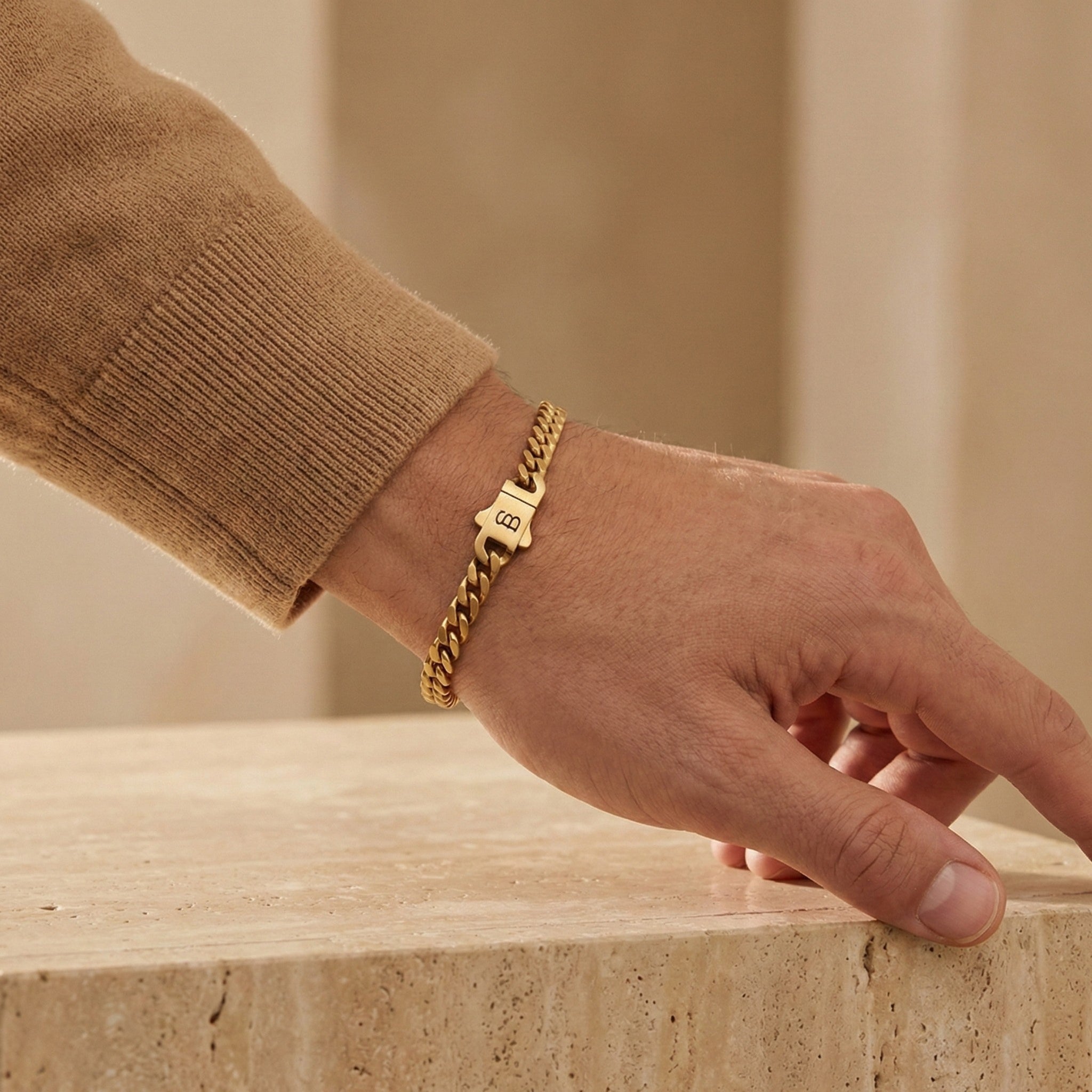 Gold toned stainless steel men’s bracelet with Cuban chain links and plated 18K gold clasp shown on wrist